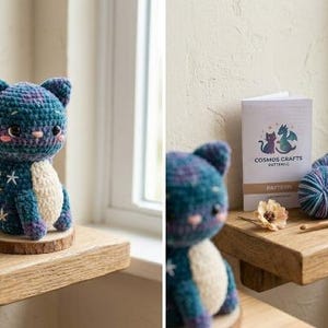 May include: A crocheted cat-dragon hybrid plush with blue and purple variegated yarn, white star embroidery, and a cream-colored belly. Beside it sits a Cosmos Crafts pattern booklet, two balls of matching yarn, and a wooden crochet hook.