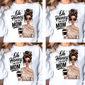 以下が含まれることがあります： 「Oh Honey I AM THAT MOM」の文字と、サングラスをかけコーヒーカップを持った女性のグラフィックがプリントされた白いスウェットシャツ。女性はヒョウ柄のヘアバンドとストライプのオフショルダーセーターを着ています。