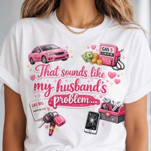 Pode incluir: Uma t-shirt branca com um carro cor-de-rosa, uma bomba de gasolina com dinheiro, uma conta de gás, chaves de carro, um batom, um smartphone rachado e uma caixa de ferramentas. O texto diz "That sounds like my husband's problem..." com corações.