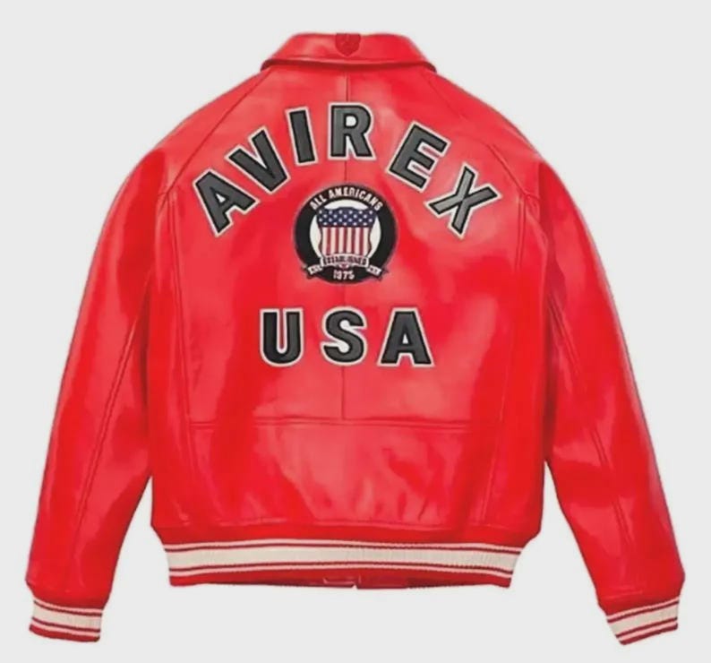Pu&ograve; includere: Giacca in pelle rossa con la scritta "AVIREX" in lettere bianche sulle spalle. La giacca presenta una toppa circolare con le scritte "ALL AMERICANS" e "ESTABLISHED 1975". La parola "USA" &egrave; stampata in lettere bianche.