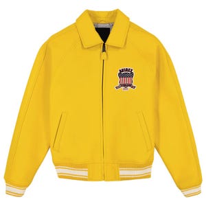 Pu&ograve; includere: Giacca giallo brillante con zip, colletto e polsini e orlo a coste. La giacca presenta una toppa sul petto con un disegno a scudo e la scritta "AVIREX ESTABLISHED 1975". I polsini e l'orlo hanno strisce bianche.