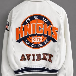 May include: White leather jacket featuring the New York Knicks logo in orange and navy blue on the back. The jacket also has the word "AVIREX" in orange lettering and a striped navy blue and white trim.