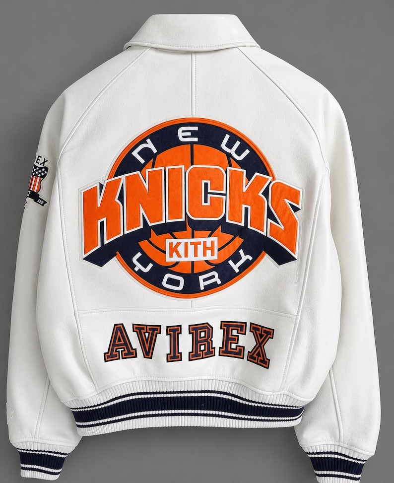 May include: White leather jacket featuring the New York Knicks logo in orange and navy blue on the back. The jacket also has the word "AVIREX" in orange lettering and a striped navy blue and white trim.