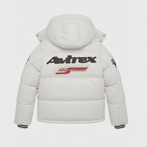Pode incluir: Casaco acolchoado branco com capuz. O casaco apresenta o nome da marca "Avirex" em letras pretas nas costas, com "All Star Leaders" por baixo. O casaco tem punhos listrados em preto e branco e patches nas mangas.