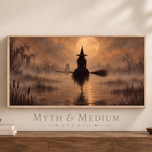 May include: A rectangular wall art print featuring a witch in a pointed hat and a small ghost riding a broomstick over a misty swamp at sunset. The scene includes a large full moon, silhouetted trees, and water ripples. Text reads Myth & Medium Studio.