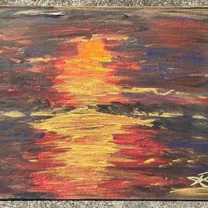 May include: An abstract painting of a sunset over water. The artwork uses a vibrant mix of colours, including shades of orange, red, yellow, and blue. The brushstrokes create a textured effect, with the artist's signature in the bottom right corner.