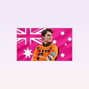 Op de afbeelding: Een jonge man in een oranje racepak staat voor een roze Australische vlag. Het pak heeft zwarte accenten en sponsorlogo's. De vlag toont de Union Jack en witte sterren.