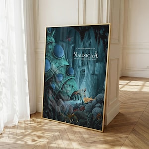 K&ouml;nnte beinhalten: Gerahmtes Poster mit dem Filmtitel "Nausica&auml; aus dem Tal der Winde". Das Kunstwerk zeigt eine fantastische Waldszene mit einem gro&szlig;en, teal-farbenen, insektenartigen Wesen und einer Figur in gelber Kleidung. Das Poster hat einen goldenen Rahmen.