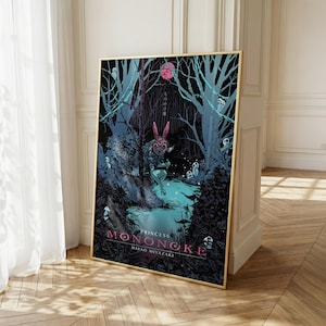 May include: A framed art print of Princess Mononoke. The artwork depicts a forest scene with a figure wearing a mask with pink rabbit ears. The print has a gold frame and is leaning against a wall. The text "Princess Mononoke" and "Hayao Miyazaki" are visible.