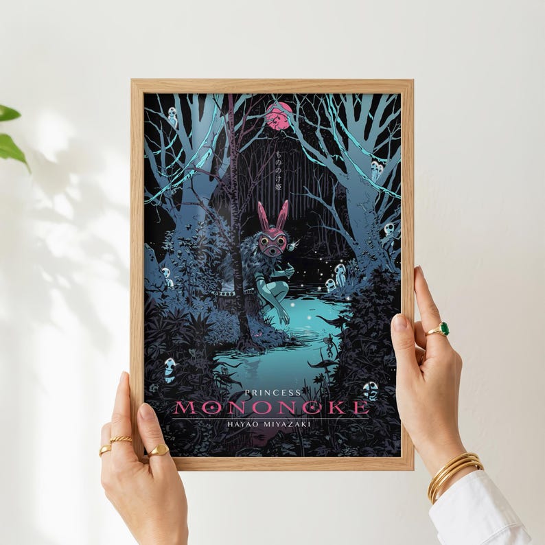 May include: A framed art print featuring a scene from Princess Mononoke. The artwork depicts a forest with a figure wearing a rabbit mask. The title and artist's name are displayed in pink and white text at the bottom.
