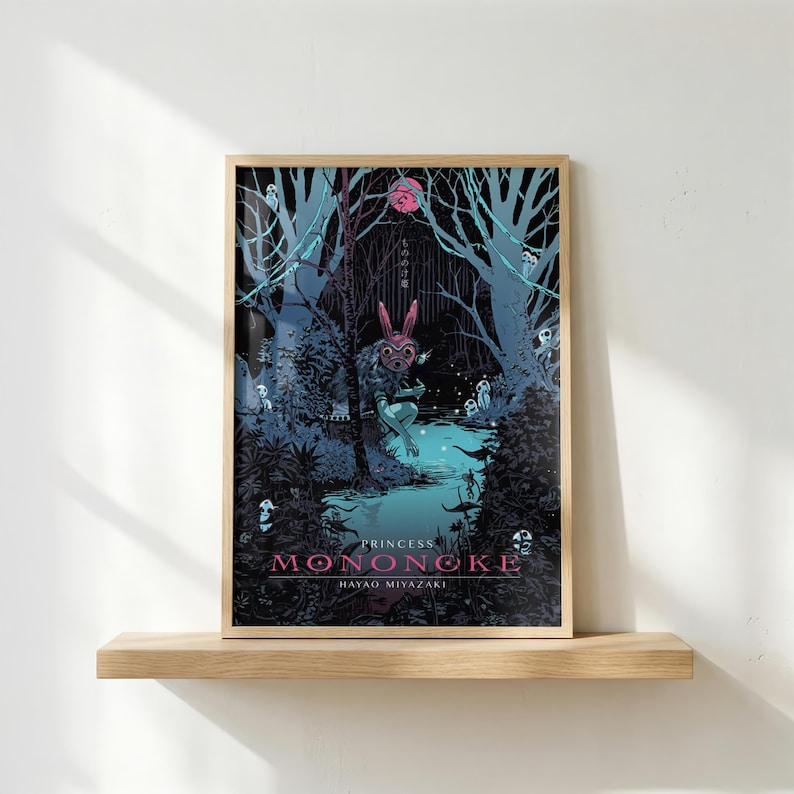 May include: A framed art print featuring a scene from "Princess Mononoke." The artwork depicts a forest with a figure wearing a pink mask, surrounded by trees and glowing creatures. The title and Hayao Miyazaki's name are at the bottom.