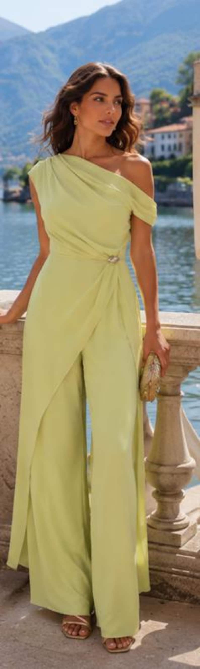 May include: A light lime green one-shoulder jumpsuit featuring a draped bodice, a fitted waist with a decorative silver-toned accent, and wide-leg trousers with an integrated wrap-style overlay panel that extends to the floor.