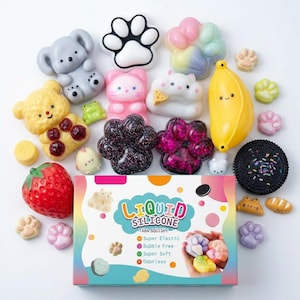 May include: A collection of various squishy toys including a grey koala, a yellow bear, a red strawberry, a yellow banana, a black cookie, and multiple paw-shaped items. A rectangular box labelled Liquid Silicone Taba Squishy is centred below.