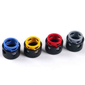 May include: Four small metal rings with different colored inserts. The rings are black with a silver-colored metal band around the top. The inserts are blue, yellow, red, and gray.
