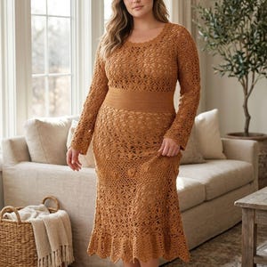 May include: A long, brown crochet dress with long sleeves. The dress has a fitted waist, a flared skirt with a ruffled hem, and an openwork design. The dress is a stylish example of handmade apparel, perfect for a special occasion. The dress is a warm, earthy tone.
