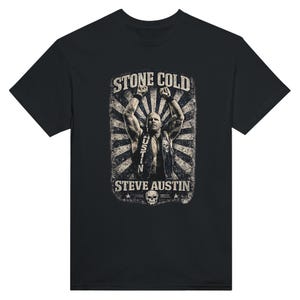 May include: Black t-shirt featuring a distressed graphic of Stone Cold Steve Austin with his arms raised. The design includes the text "STONE COLD" above the image and "STEVE AUSTIN" below, with a skull and stars.