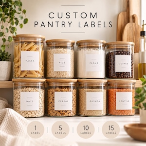May include: Eight clear glass storage jars with bamboo lids, each featuring a white square label with black text reading Pasta, Rice, Flour, Coffee, Oats, Cereal, Quinoa, and Lentils. The text Custom Pantry Labels appears above the jars.