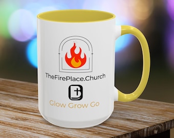 May include: White ceramic mug with a yellow interior and handle. The mug features the text "TheFirePlace.Church" and "Glow Grow Go" along with a graphic of a flame inside an arch.