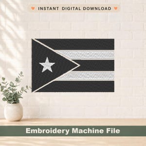 May include: A black and white embroidered flag design with a star and stripes. The text "INSTANT DIGITAL DOWNLOAD" is at the top, and "Embroidery Machine File" is at the bottom. The design is displayed on a white brick wall.