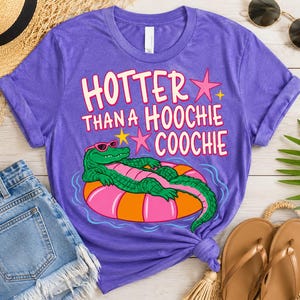 May include: A purple t-shirt featuring the phrase "Hotter Than a Hoochie Coochie" and a cartoon alligator in sunglasses on an inflatable ring. The image includes denim shorts, sunglasses, and sandals.