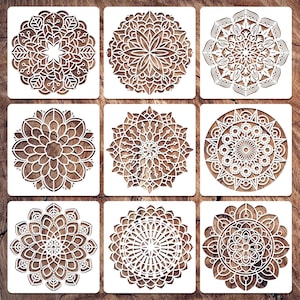 May include: Nine square stencils with intricate mandala designs. Each stencil features a different circular pattern cut out of white plastic, set against a wooden background. The designs include floral and geometric elements.
