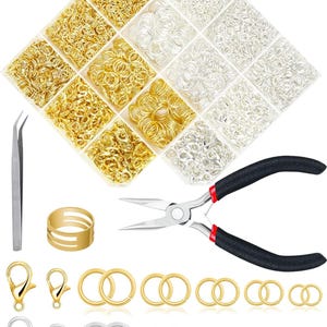 May include: A jewelry-making kit with gold and silver jump rings, clasps, and tools. The kit includes a divided container of jump rings, a pair of pliers, tweezers, and a gold ring. The jump rings are in various sizes and shapes.