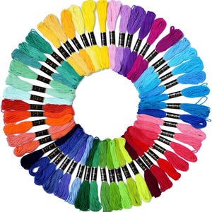 May include: A circular arrangement of colorful embroidery floss in a variety of shades, including yellow, green, blue, pink, and purple. Each skein is neatly bundled with a black label. The floss is ideal for embroidery, cross-stitch, and other needlecraft projects.