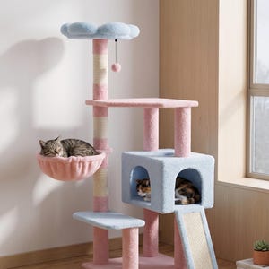 Könnte beinhalten: Ein mehrstöckiger Katzenbaum in Pastellrosa und Blau mit einem wolkenförmigen Oberteil, einer Hängematte und einem Häuschen. Der Katzenbaum hat einen Kratzbaum und eine Rampe. Zwei Katzen ruhen sich auf dem Katzenbaum aus.
