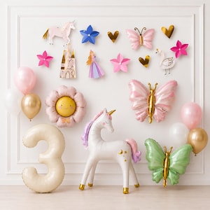 May include: A collection of party decorations including a large number 3 balloon, a white unicorn balloon, a pink flower balloon, and two butterfly balloons in pink and green. Wall cutouts feature a unicorn, castle, princess, swan, and stars.