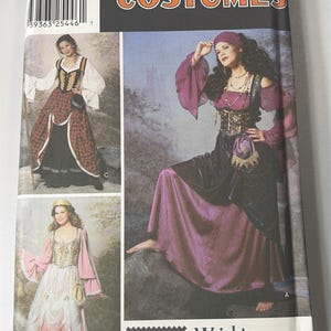 Può includere: Un modello di cucito Simplicity per costumi. La confezione presenta immagini di donne in vari modelli di costumi, tra cui un abito in stile rinascimentale e un outfit di ispirazione medievale. La confezione è nera con la parola "COSTUMES" a lettere grandi.