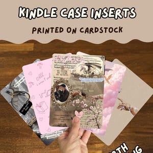May include: A collection of rectangular cardstock Kindle case inserts featuring various graphic designs, including a pink sheet with hearts and text, a collage-style print with a dragon and a couple, and a pink sky scene with a hand reaching out.