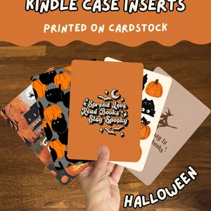 Pode incluir: Um conjunto de inserções retangulares de cartolina para capas de Kindle com designs temáticos de Halloween. A inserção frontal é laranja com o texto Spread Love Read Books Stay Spooky rodeado por morcegos e estrelas. Outros designs incluem abóboras.