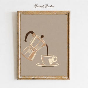 May include: Framed art print featuring a coffee pot pouring coffee into a cup and saucer. The artwork is in neutral tones of brown and beige, with the text "Berest Studio" in the upper left corner. The frame is a light brown color.