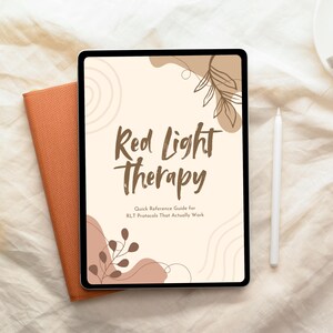 Könnte beinhalten: Ein digitales Tablet mit dem Titel "Red Light Therapy" und dem Untertitel "Quick Reference Guide for RLT Protocols That Actually Work". Ein weißer Stift und ein orangefarbenes Buch liegen neben dem Tablet. Der Hintergrund ist ein cremefarbener Stoff.