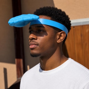 May include: A blue head visor with a hand-shaped design. The visor is worn on the head with a blue band. The person in the image is wearing a white textured shirt.