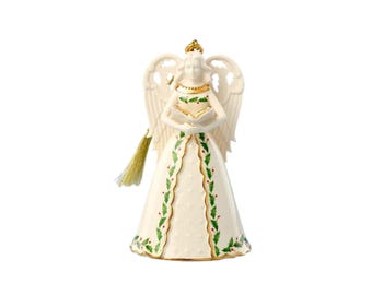 Puede incluir: Un adorno de ángel de porcelana blanca con alas grandes, un cuello con borde dorado y un vestido en forma de campana decorado con hojas de acebo verdes y bayas rojas. El ángel sostiene un libro abierto e incluye una borla dorada.