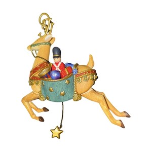 Puede incluir: Una figura de reno color canela con astas doradas, que lleva un arnés rojo y dorado. Transporta un tambor verde azulado decorado con estrellas doradas, que contiene un pequeño soldado de juguete, una bola azul y un regalo rojo.