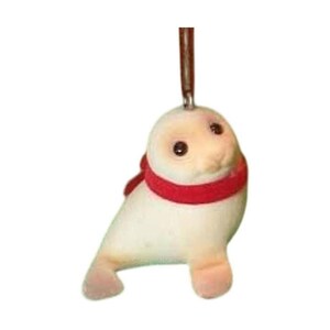 May include: A small, cream-colored seal figurine with a smooth, flocked texture. The seal has dark, round eyes and a small nose, and it is wearing a bright red scarf around its neck. A thin, brown metal loop is attached to the top of its head.