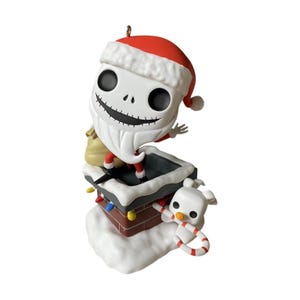 May include: A figurine of a white skeletal character wearing a red Santa hat and beard, emerging from a brick chimney with snow on top. A small white ghost dog with a candy cane is attached to the side, and colorful Christmas lights decorate the chimney.