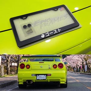 Puede incluir: Marco de matrícula negro con el texto "Epic Frames" y texto japonés "ゴースト". Incluye accesorios de montaje. El marco se muestra en un coche verde brillante.