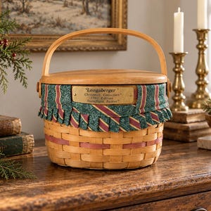 Peut inclure: Un panier rond en bois tressé avec une anse en bois clair et un couvercle en bois. Le panier présente une doublure en tissu vert et rouge avec un bord volanté et une plaque en laiton indiquant Longaberger Christmas Collection 1997 Edition Snowflake Basket.
