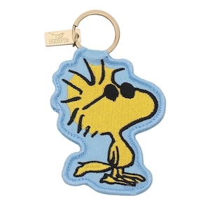 May include: A yellow embroidered bird character wearing black sunglasses on a light blue background, attached to a gold-toned metal keyring with a small rectangular tag featuring the text MAGPIE and a bird icon.
