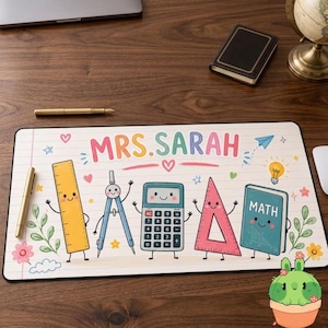 May include: A rectangular desk mat featuring a lined paper background with the text MRS. SARAH in colorful letters. The design includes cartoon illustrations of a yellow ruler, a blue compass, a calculator, a pink triangle, and a green math book.