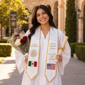 Op de afbeelding: Een afgestudeerde in een witte toga lacht, met een boeket bloemen en een diploma. De afstudeerband draagt de tekst "Sophia Elizabeth Jenkins" en "Klasse van 2026" met de Amerikaanse vlag en de Mexicaanse vlag.