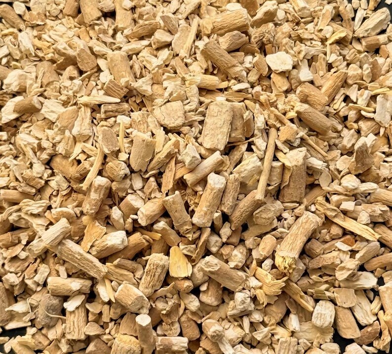 May include: A close-up shot of a pile of chopped, dried, tan-coloured roots and stems. The pieces vary in size and shape, with some appearing cylindrical and others more irregular. The texture is rough and fibrous, suggesting a natural product.