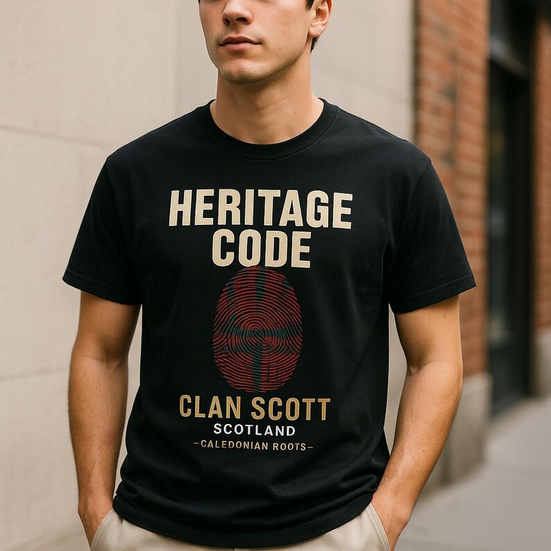 May include: A black short-sleeve t-shirt featuring the text HERITAGE CODE in beige, a red and black fingerprint graphic with a cross pattern, and the text CLAN SCOTT SCOTLAND -CALEDONIAN ROOTS- in beige lettering centered on the chest.