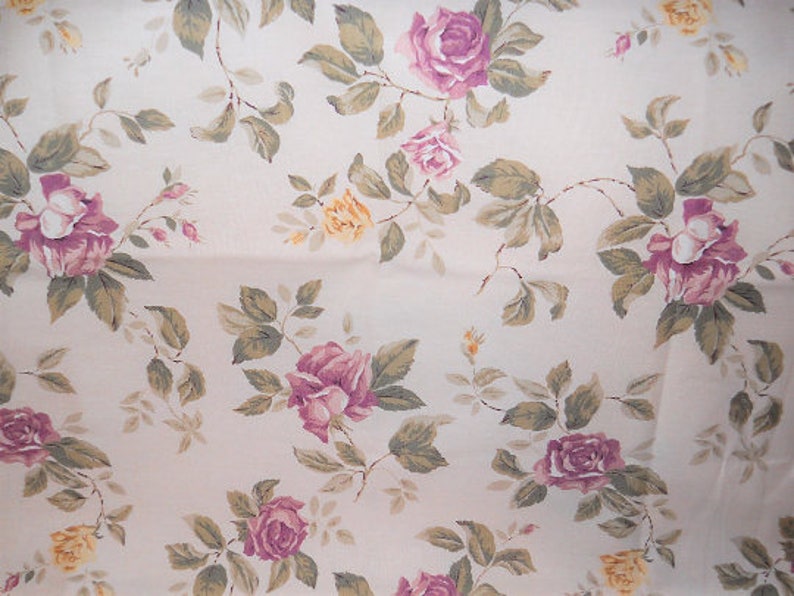 Puede incluir: Una tela de color crema con un patr&oacute;n repetido de rosas rosas y amarillas y hojas verdes.