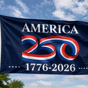 May include: A navy blue flag with the word "AMERICA" in white block letters. The number "250" is displayed in red, white, and blue ribbon-like design. The years "1776-2026" are below the number, with stars on either side.