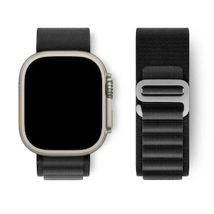 May include: A silver smartwatch with a black screen and a black fabric band. The band is connected to the watch and also shown separately. The watch has a rectangular face with rounded corners and a side button.