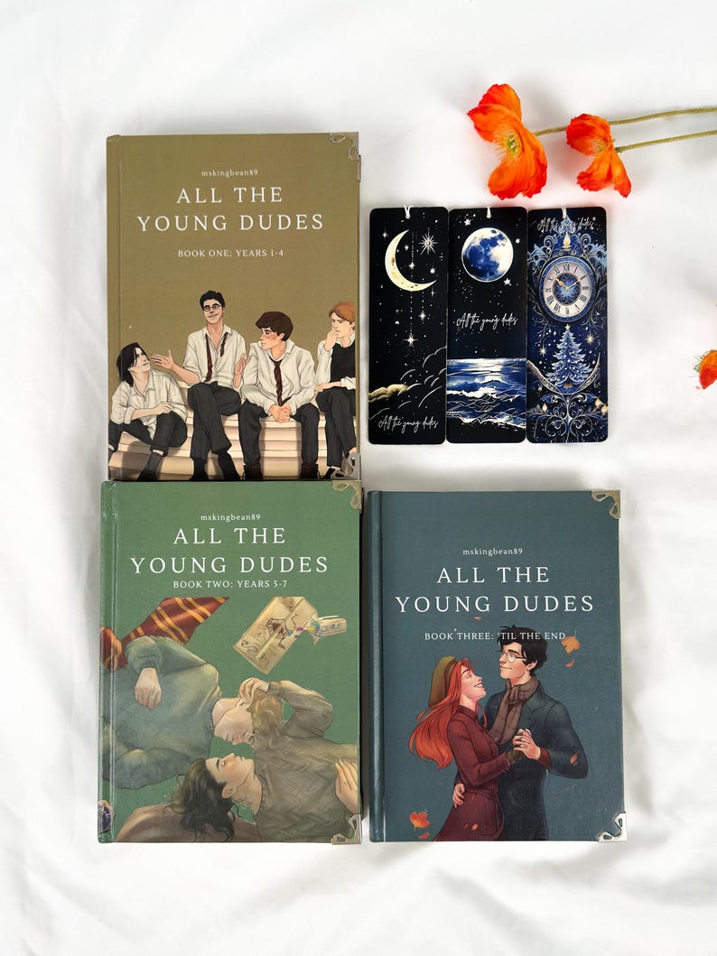 Op de afbeelding: Vier boeken en drie bladwijzers worden getoond op een witte ondergrond. De boeken hebben de titel "All The Young Dudes" met verschillende omslagillustraties. De bladwijzers hebben hemelse en winterse ontwerpen. Oranje bloemen zijn bij de boeken geplaatst.